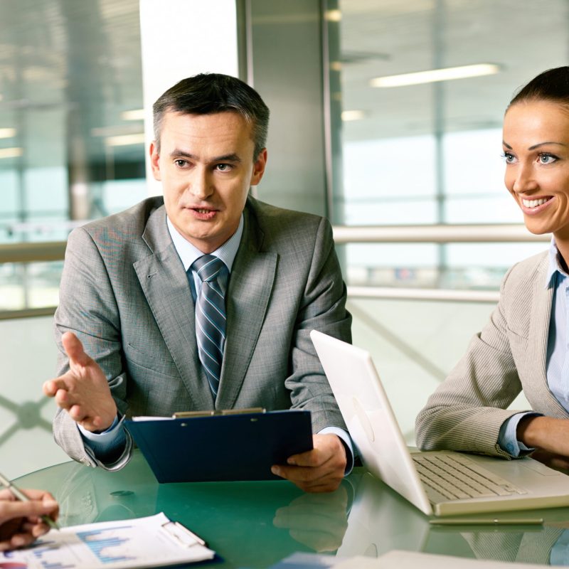Group of business partners interacting at meeting in office